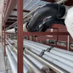 Interconexión de tuberías industriales de acero y polietileno instaladas en una pasarela técnica exterior, con soportes metálicos y uniones bridadas preparada por Soldaduras Dad, expertos en sistemas de fluidos industriales en Zaragoza