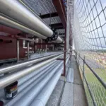 Tuberías industriales de acero inoxidable instaladas en pasarela exterior sobre estructura metálica por Soldaduras Dad